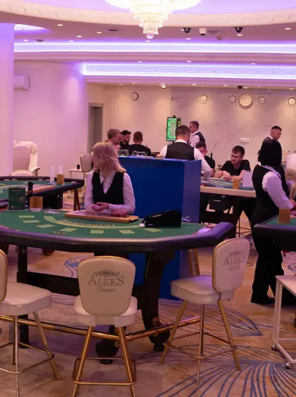 The blackjack room, dealers at their tables under the chandelier