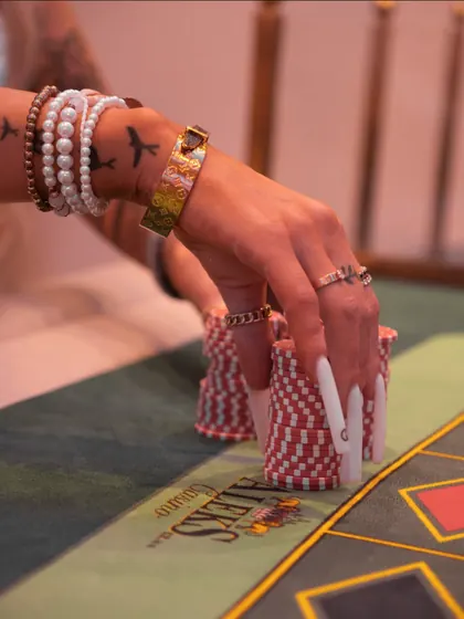 A hand resting on a stack of chips at the edge of the layout