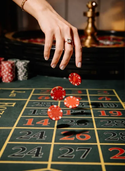A hand tossing chips onto the roulette numbers